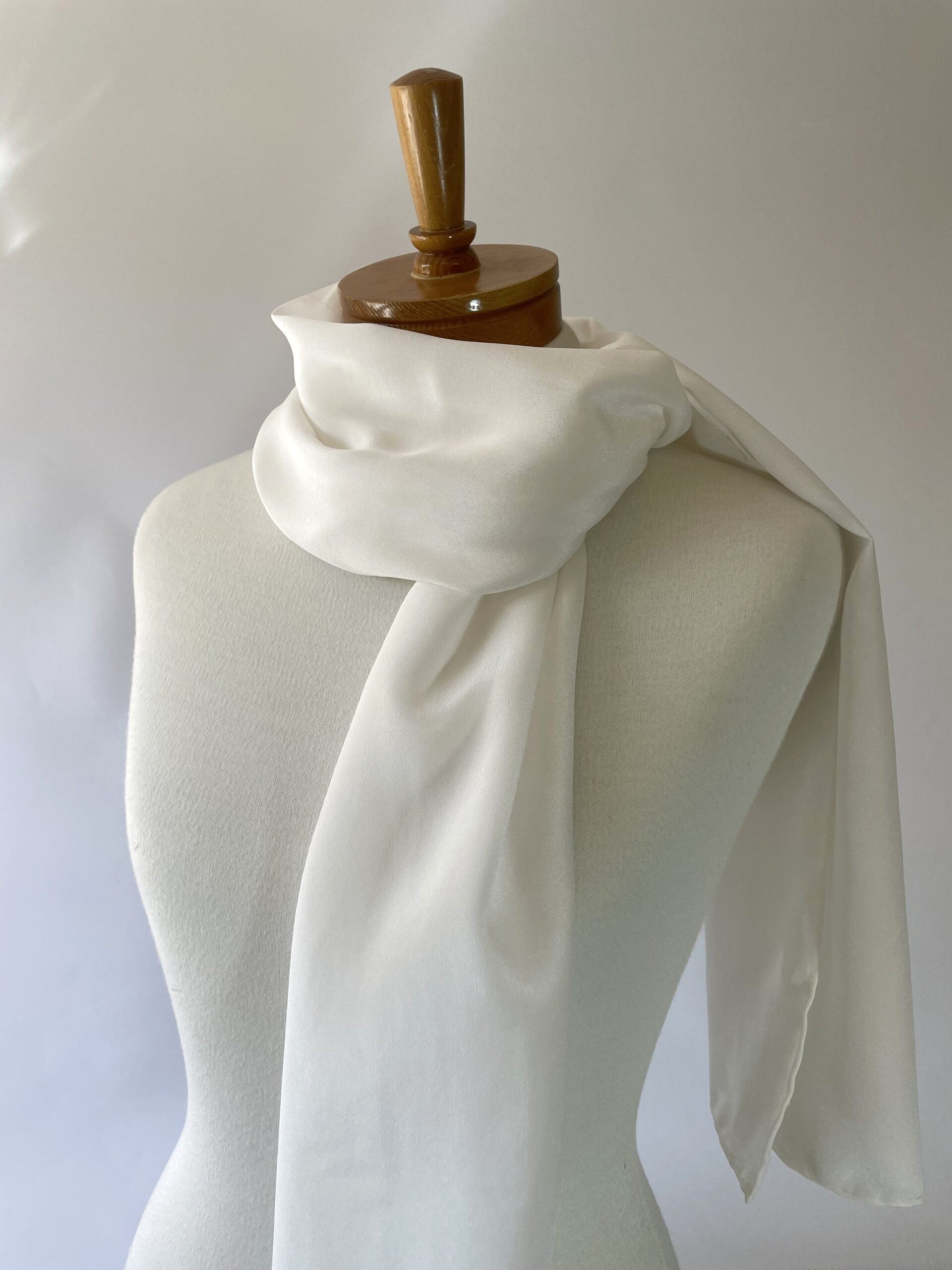 Undyed crepe de chine white scarf draped over a mannequin against a plain background