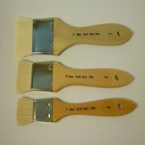 Three paint brushes with wooden handles on a beige background