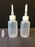 Two clear plastic dropper bottles with white caps on a dark surface.