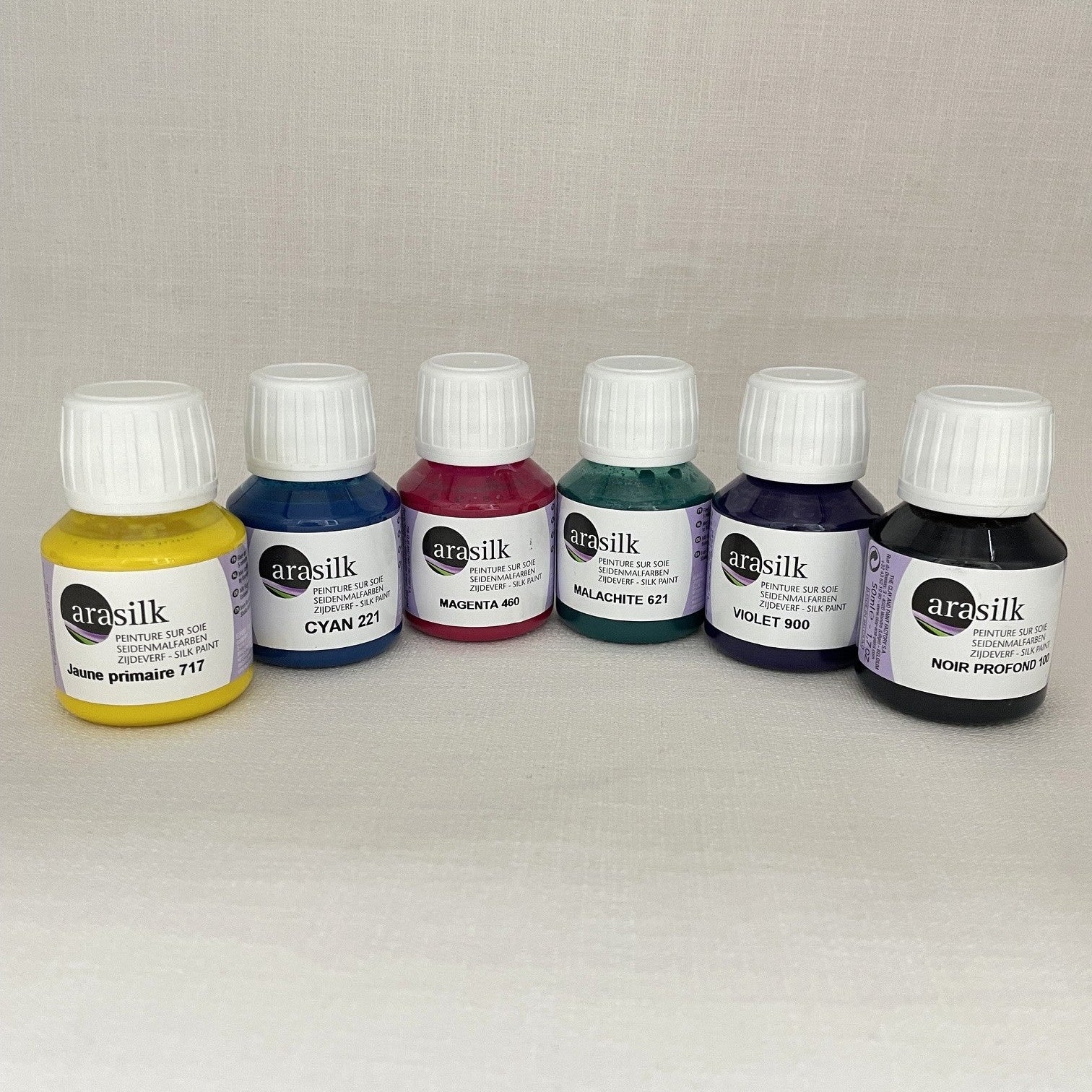 Six small bottles of Arasilk silk paint.  Colours are primary yellow cyan, magenta, malachite, violet, black