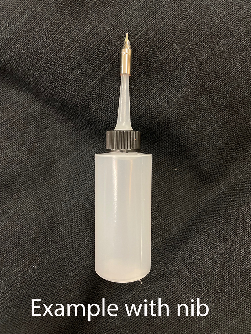 White ink bottle with a metal nib on a black textured background