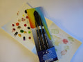 Set of watercolor brushes and swatch cards on a white surface
