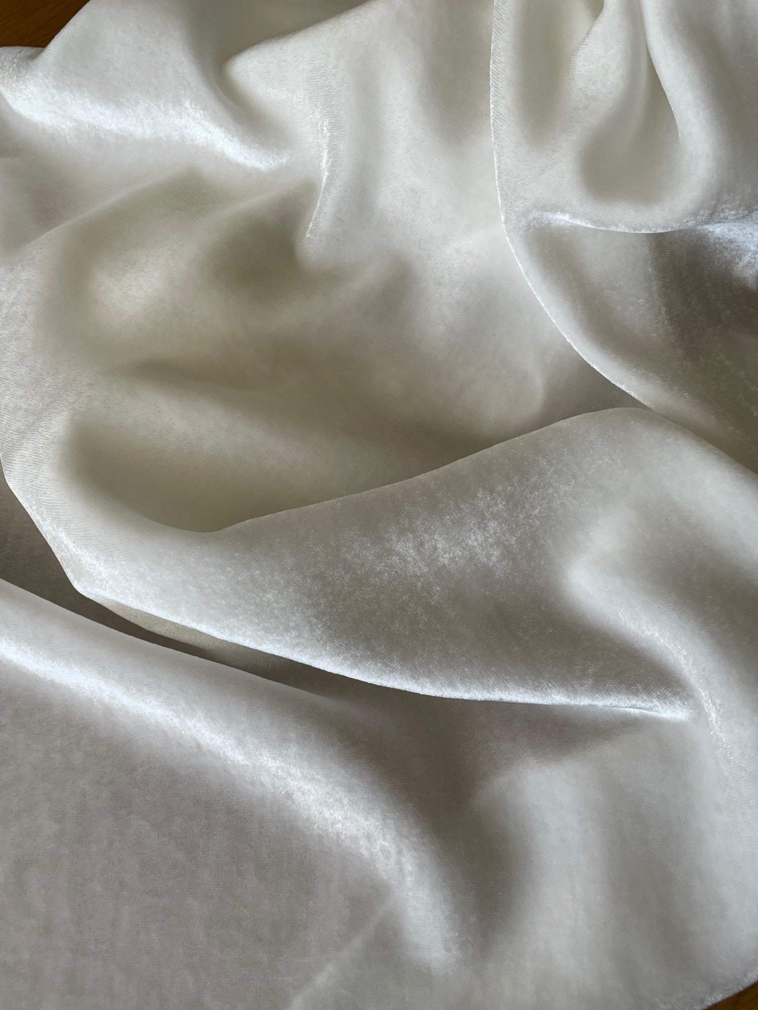 Close-up of white crumpled undyed silk viscose velvet scarf with folds