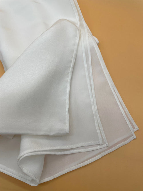 Undyed white crepe de chine scarf on a brown surface