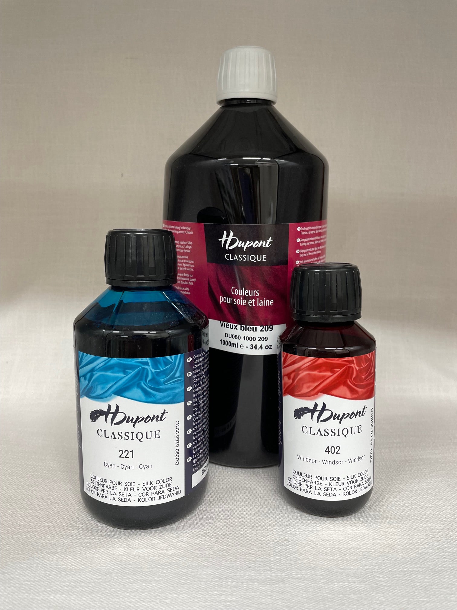Three bottles of H dupont Classique dye on a light gray background