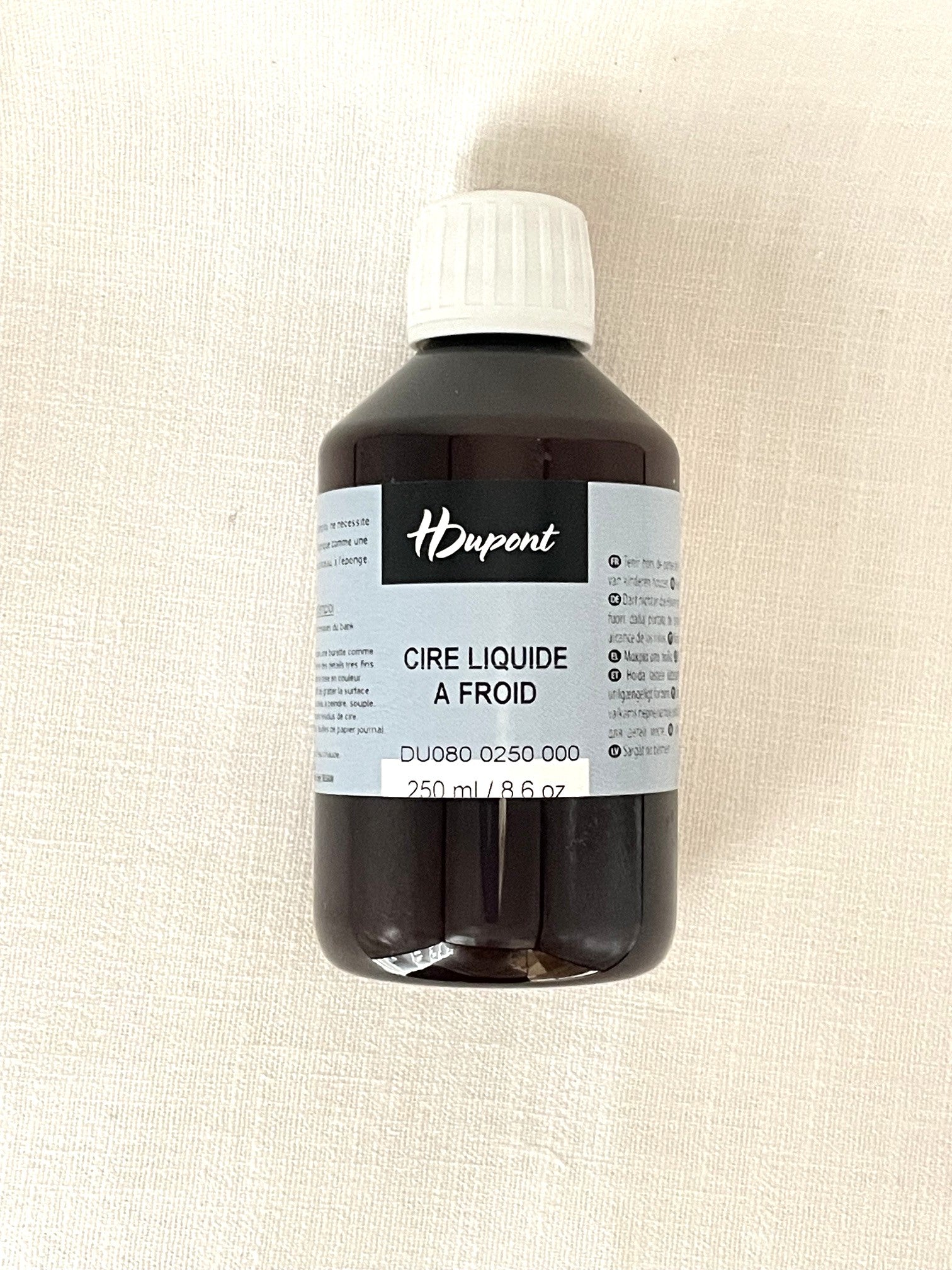 Bottle of H Dupont liquid cold wax on a white background
