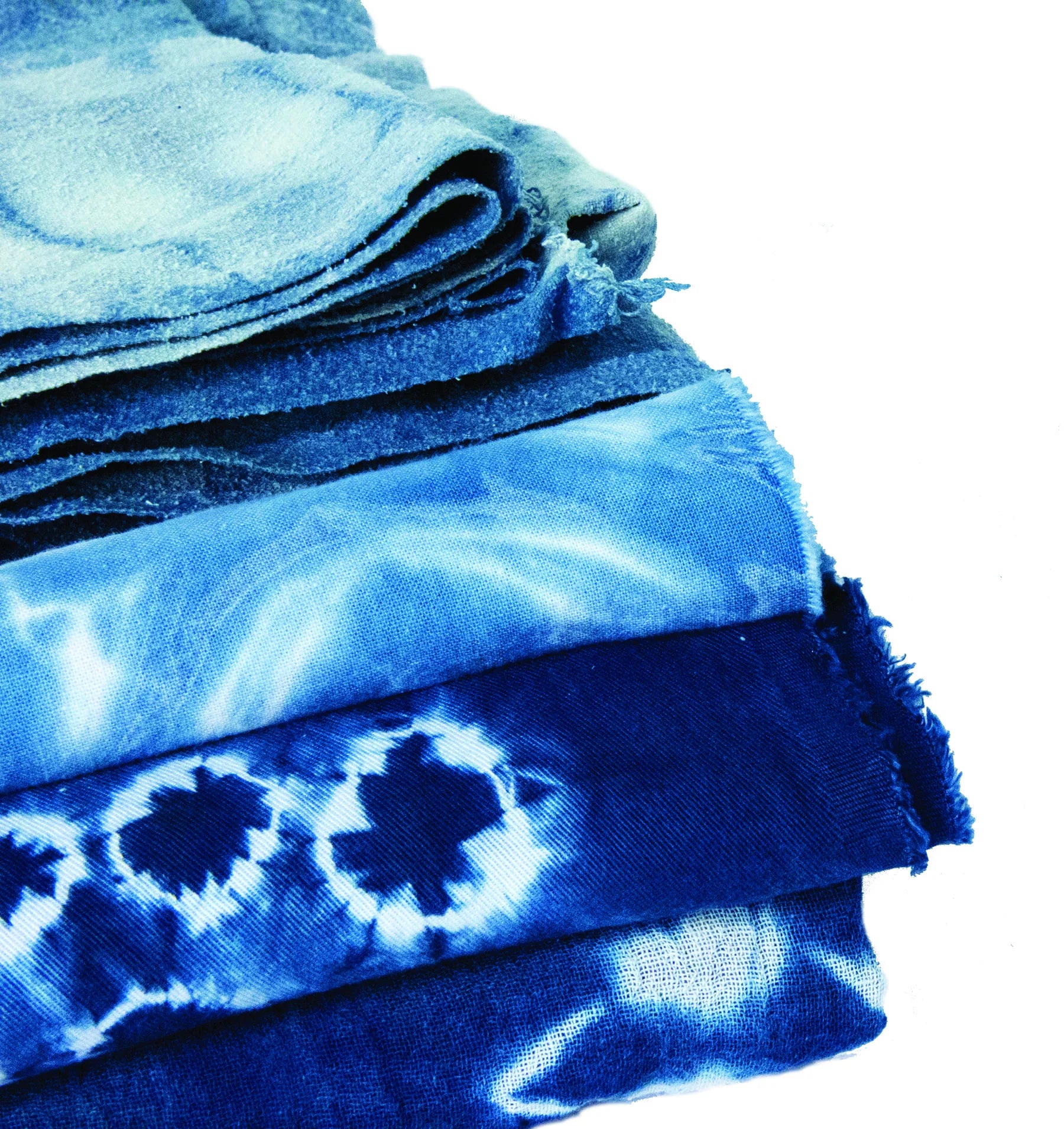 Stack of blue tie-dye fabric on a white background