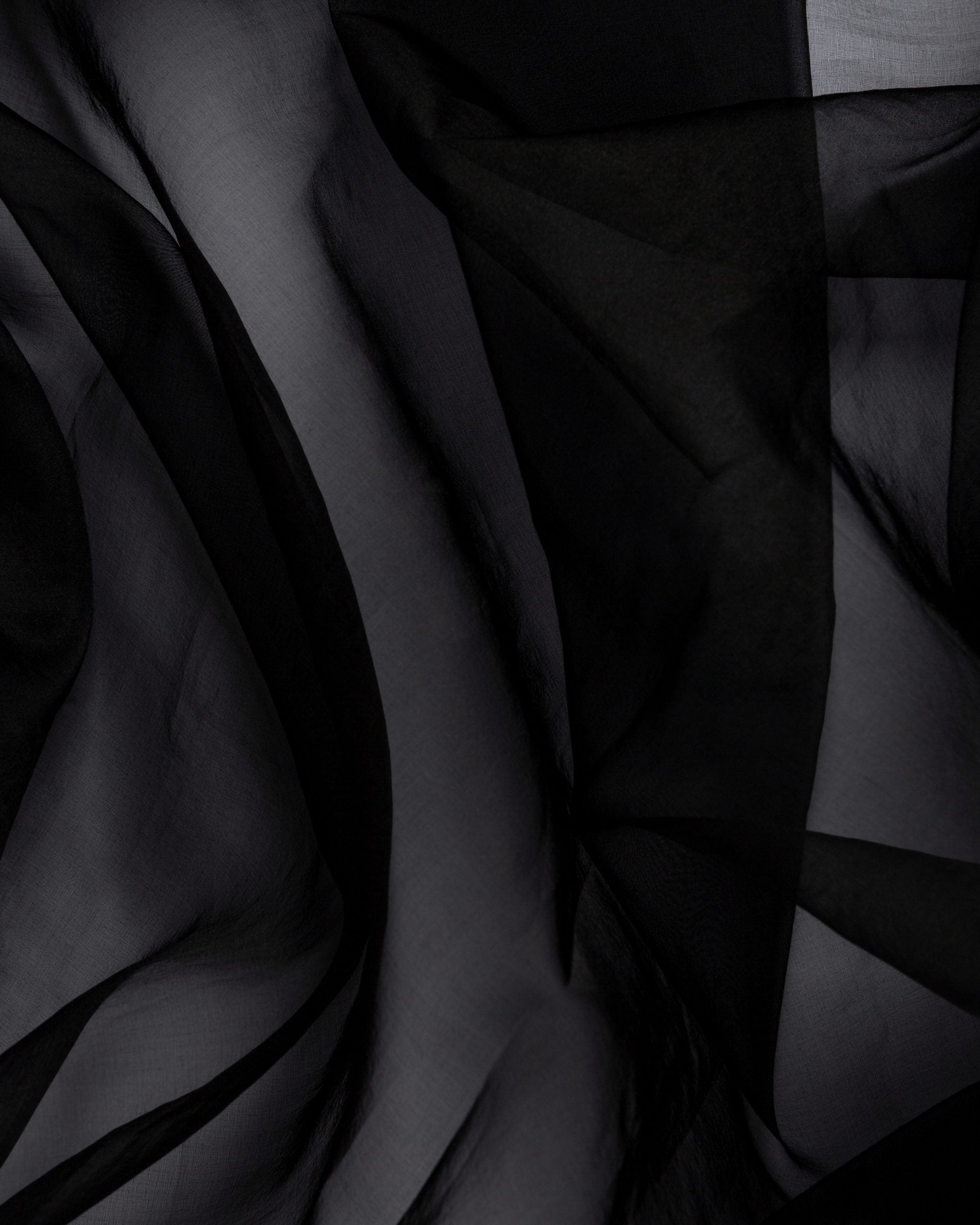 Close-up of black silk organza fabric with folds