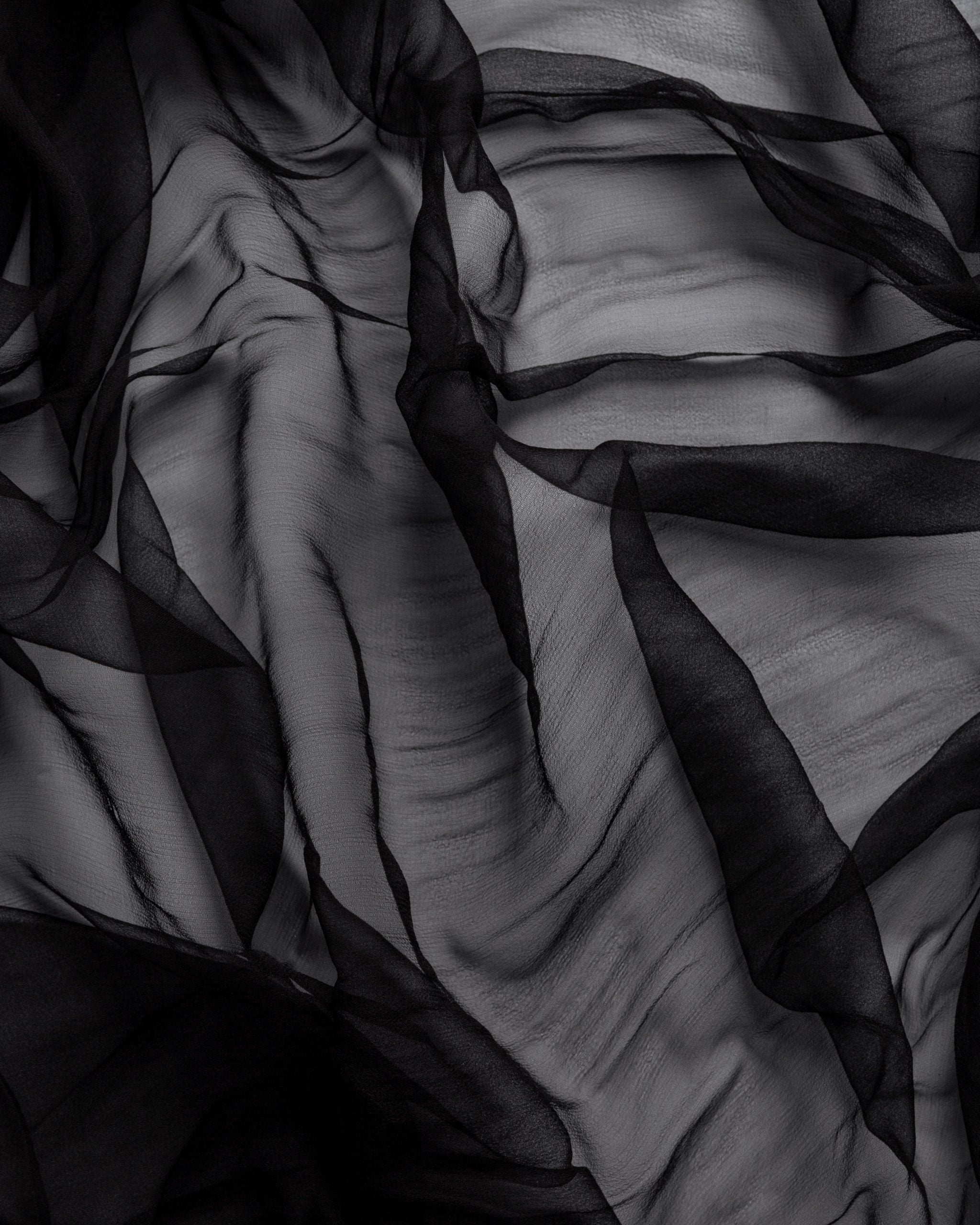 Close-up of black silk gauze fabric with a folds
