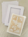 White card with gold butterfly design and matching envelope on a beige background