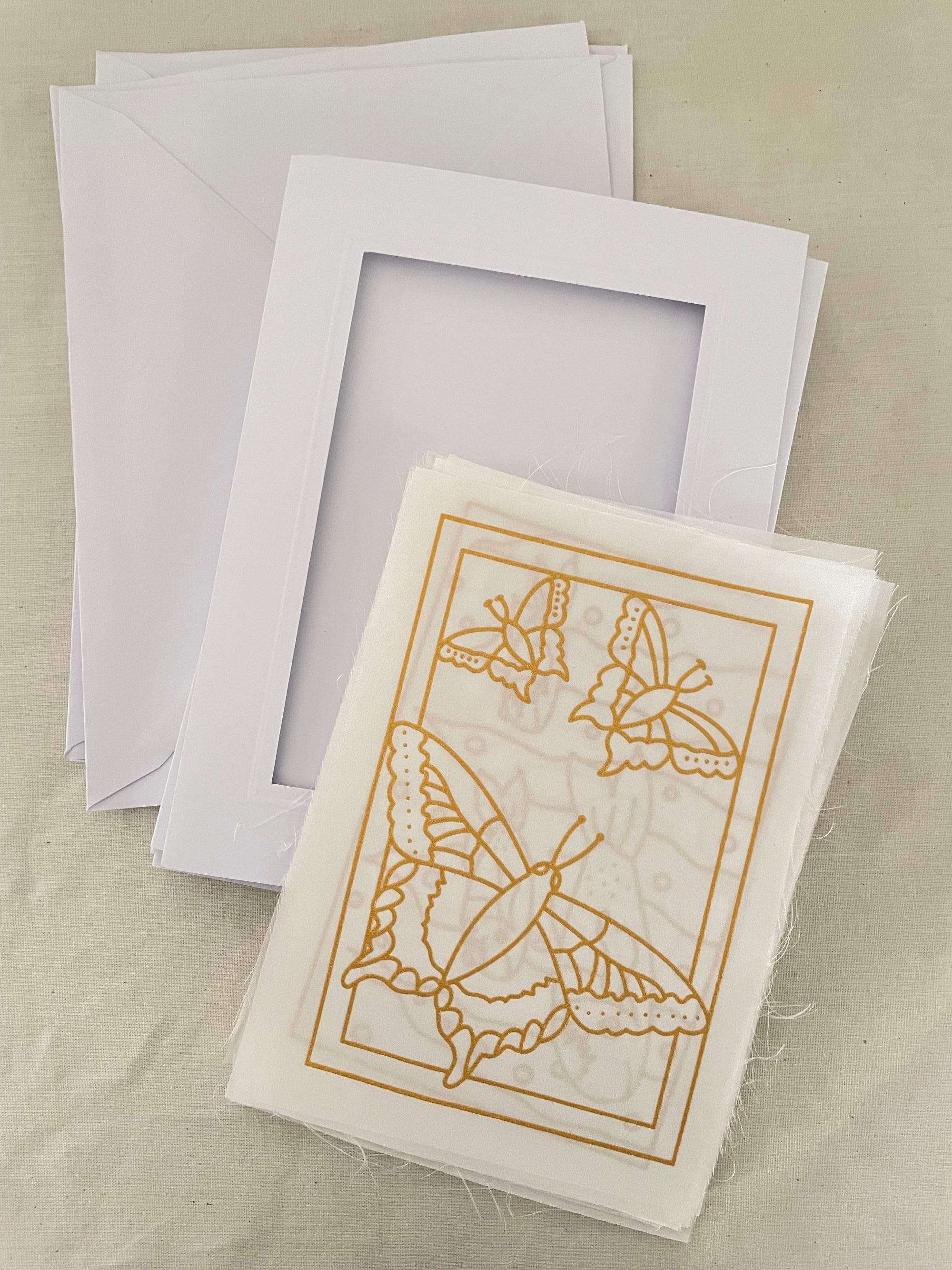White card with gold butterfly design and matching envelope on a beige background