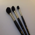 Three Silver Mop brushes with black bristles on a light gray background