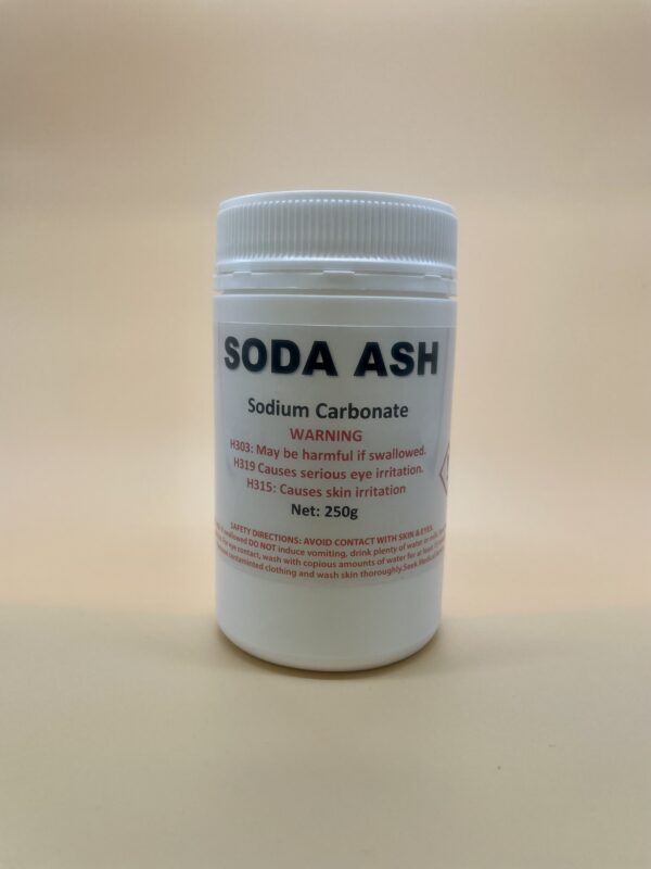 Container of soda ash with label on a beige background