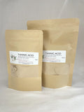 Two stand-up kraft paper pouches of Tannic Acid product, one 50g and one 250g, with white labels, set against a neutral light gray background.