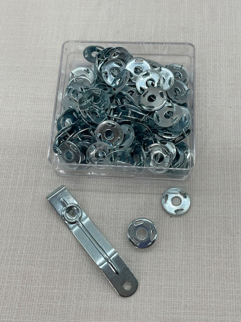 Metal pins and a metal clip on a gray surface