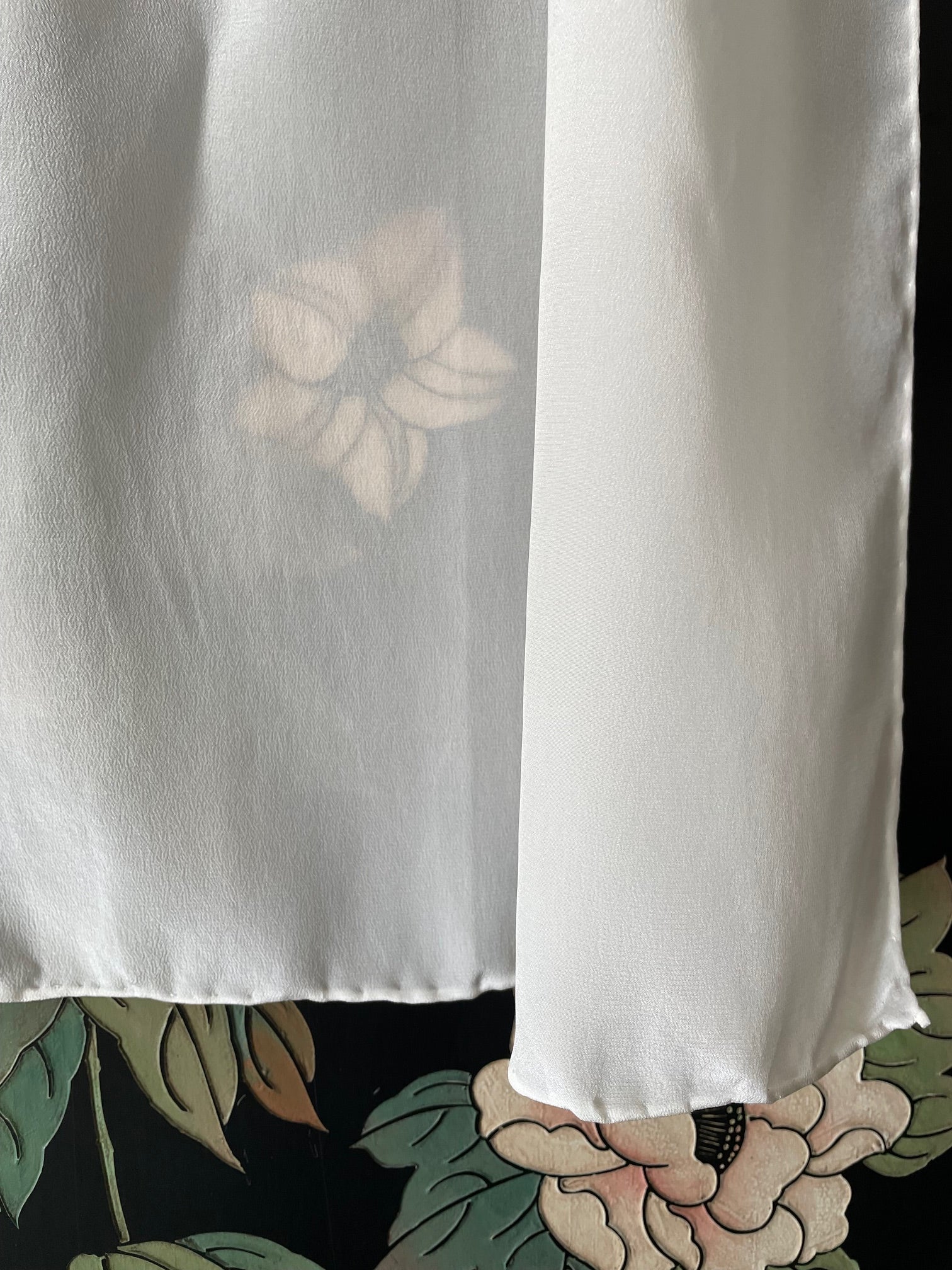 Undyed crepe de chine silk scarf against a floral background