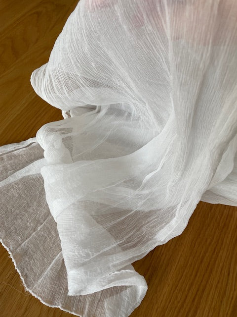 Undyed Crinkle Chiffon Scarf in folds draped over a wooden surface