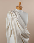 Mannequin draped with undyed white Fuji spun habutai silk fabric against a beige background