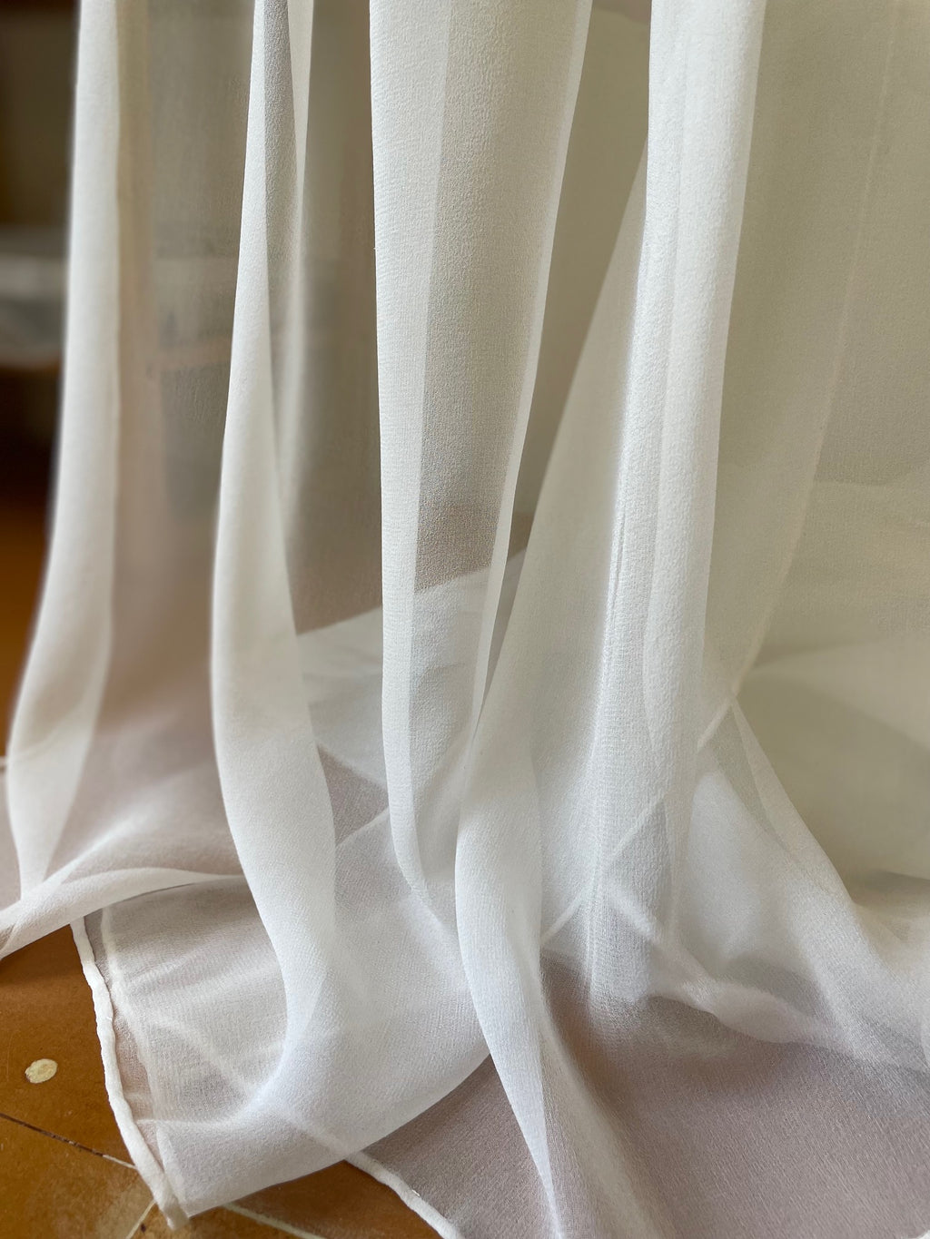 Sheer undyed white georgette silk scarf with a blurred background