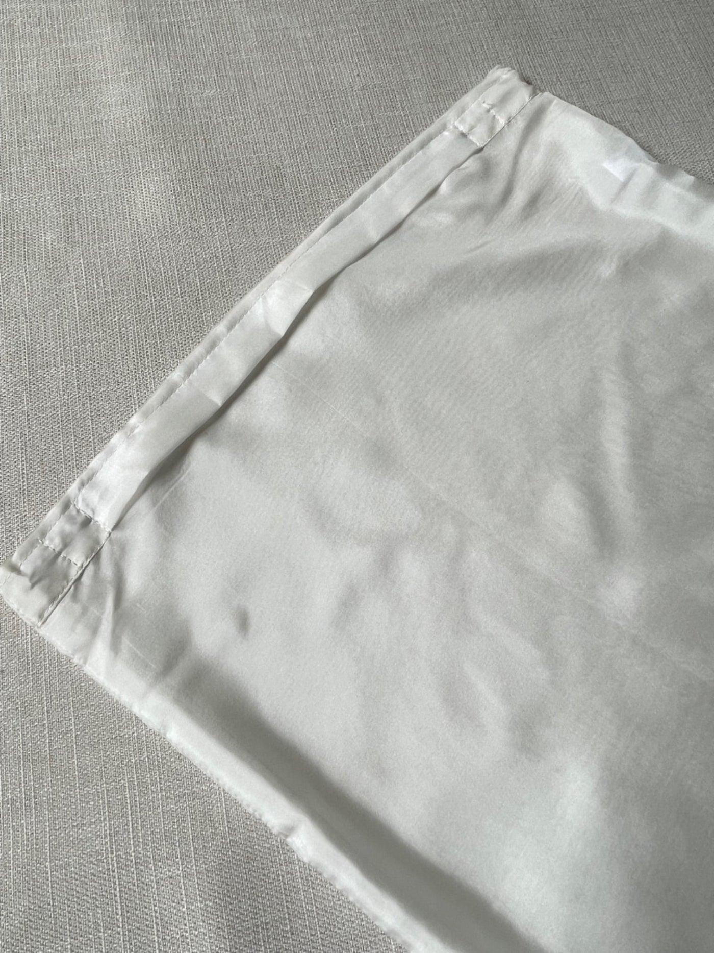 Undyed Habutai cushion cover zip section on a gray textured surface