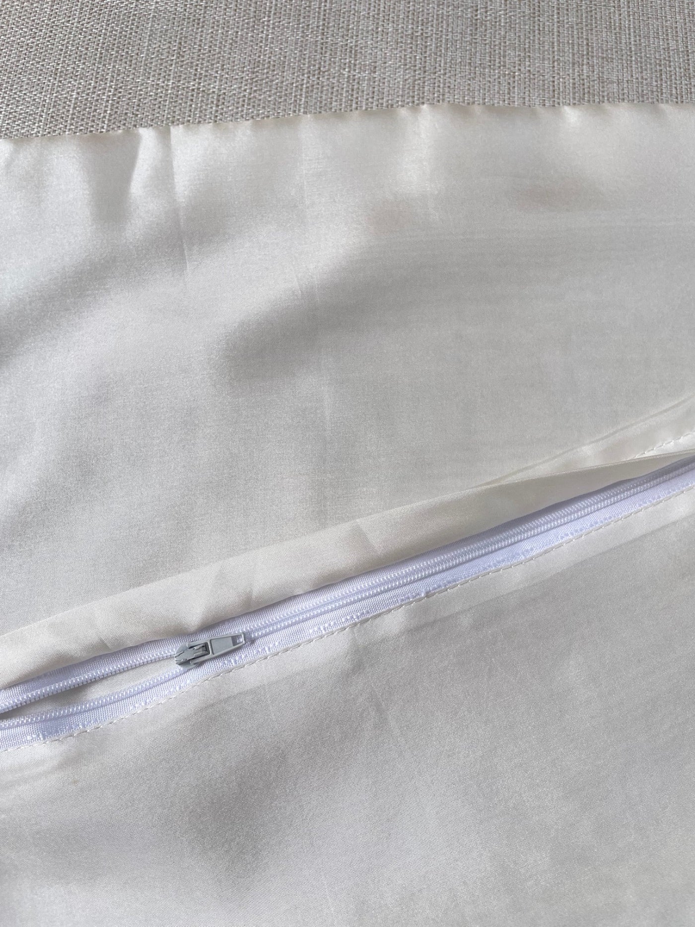Close-up of a white zipper on a textured fabric background