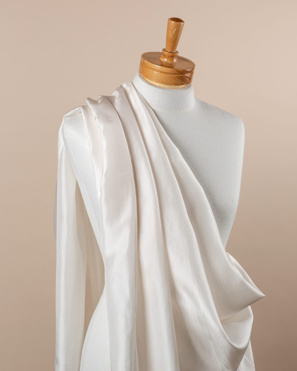 Undyed white Habutai silk fabric draped over a mannequin on a beige background
