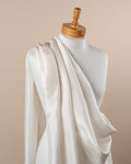 Undyed white Habutai silk fabric draped over a mannequin on a beige background