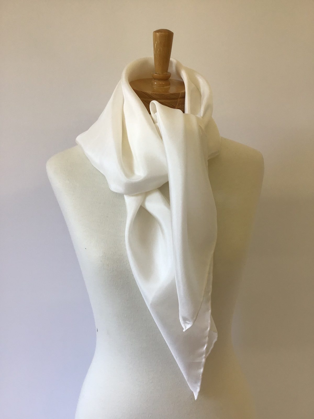 Undyed white Habutai silk scarf draped over a mannequin bust against a plain background