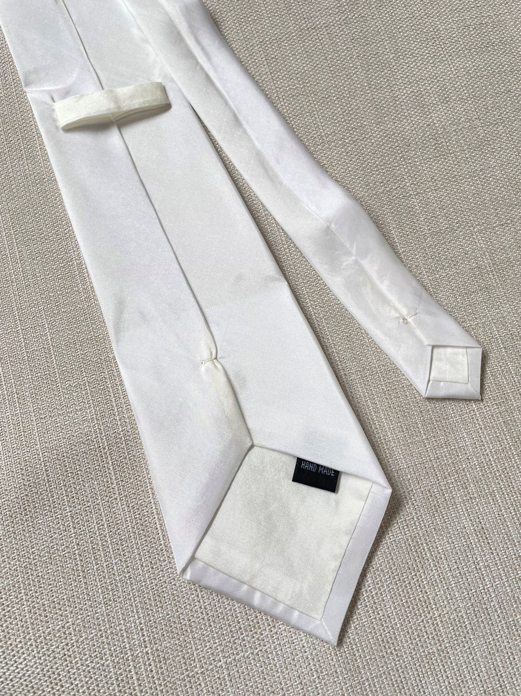 Undyed Habutai silk tie back view on a textured beige surface
