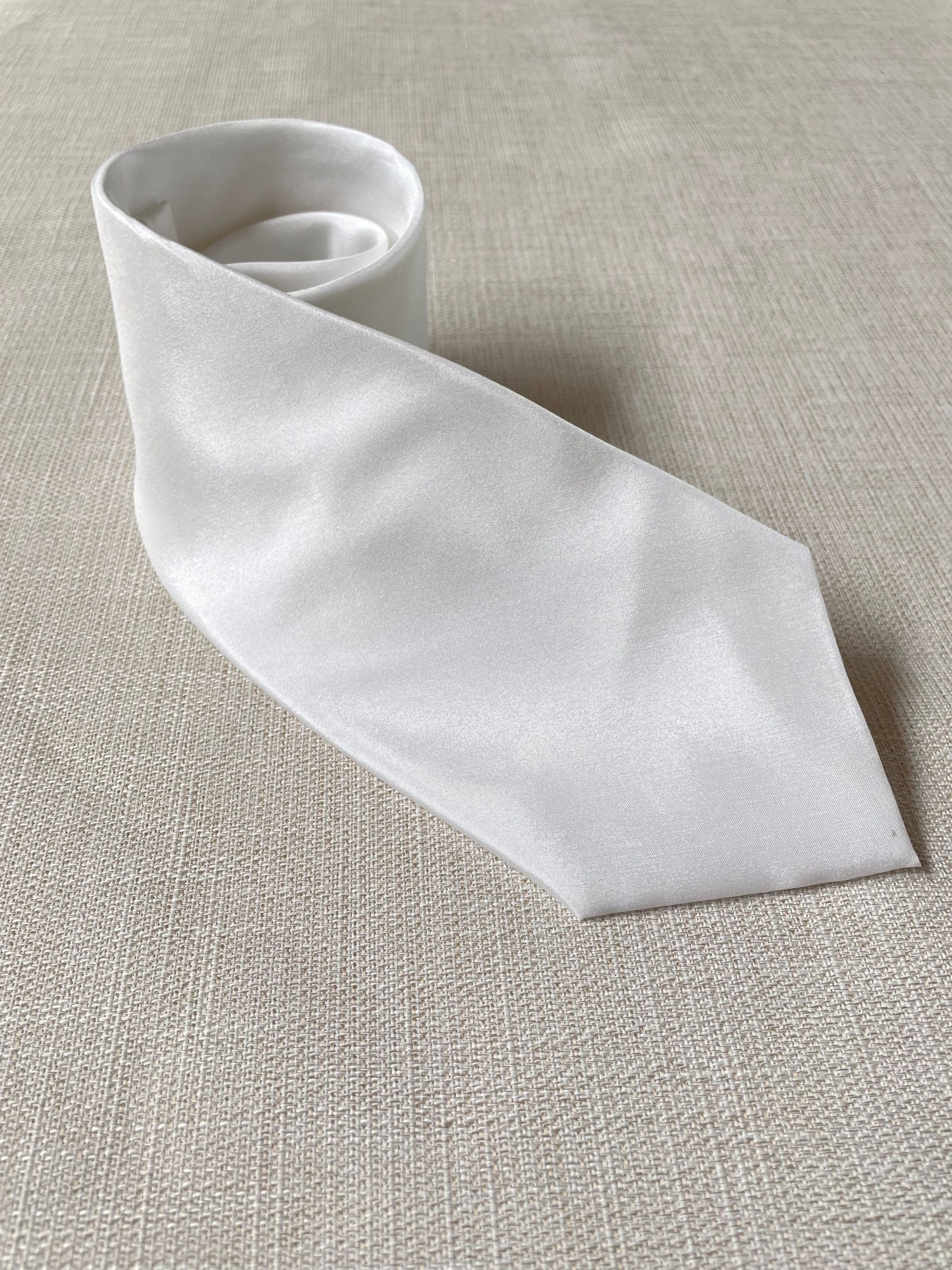 Undyed tie on a textured beige background