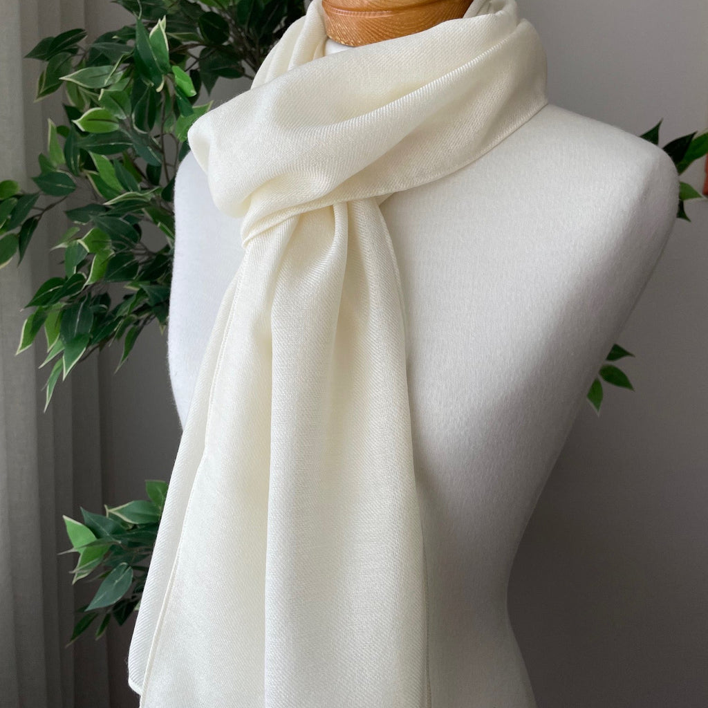 Mannequin draped with undyed lightweight wool scarf against a neutral background