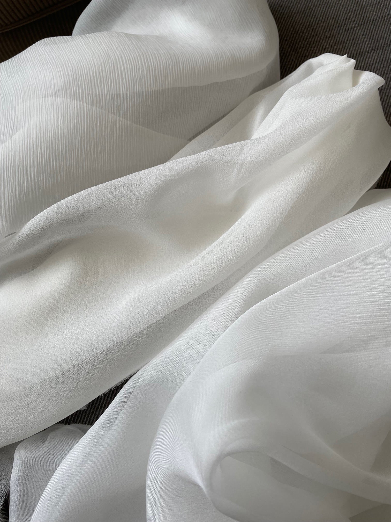 Undyed white fabric with folds on a dark background