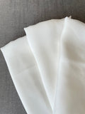 Close-up of undyed silk fabric on a gray surface