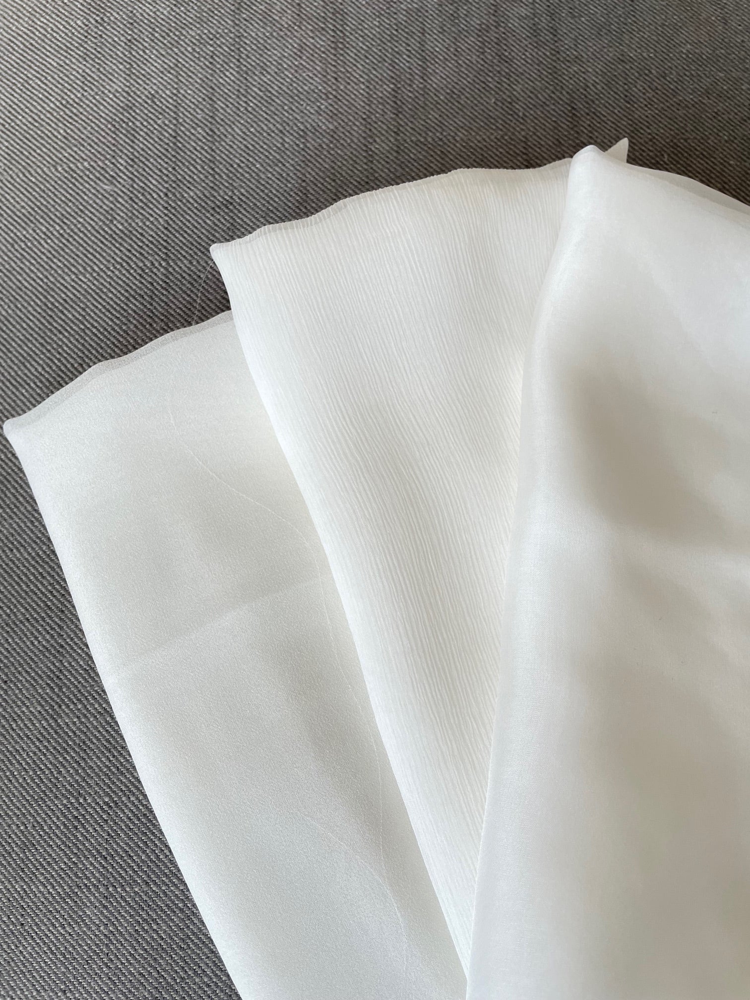 Close-up of undyed silk fabric on a gray surface