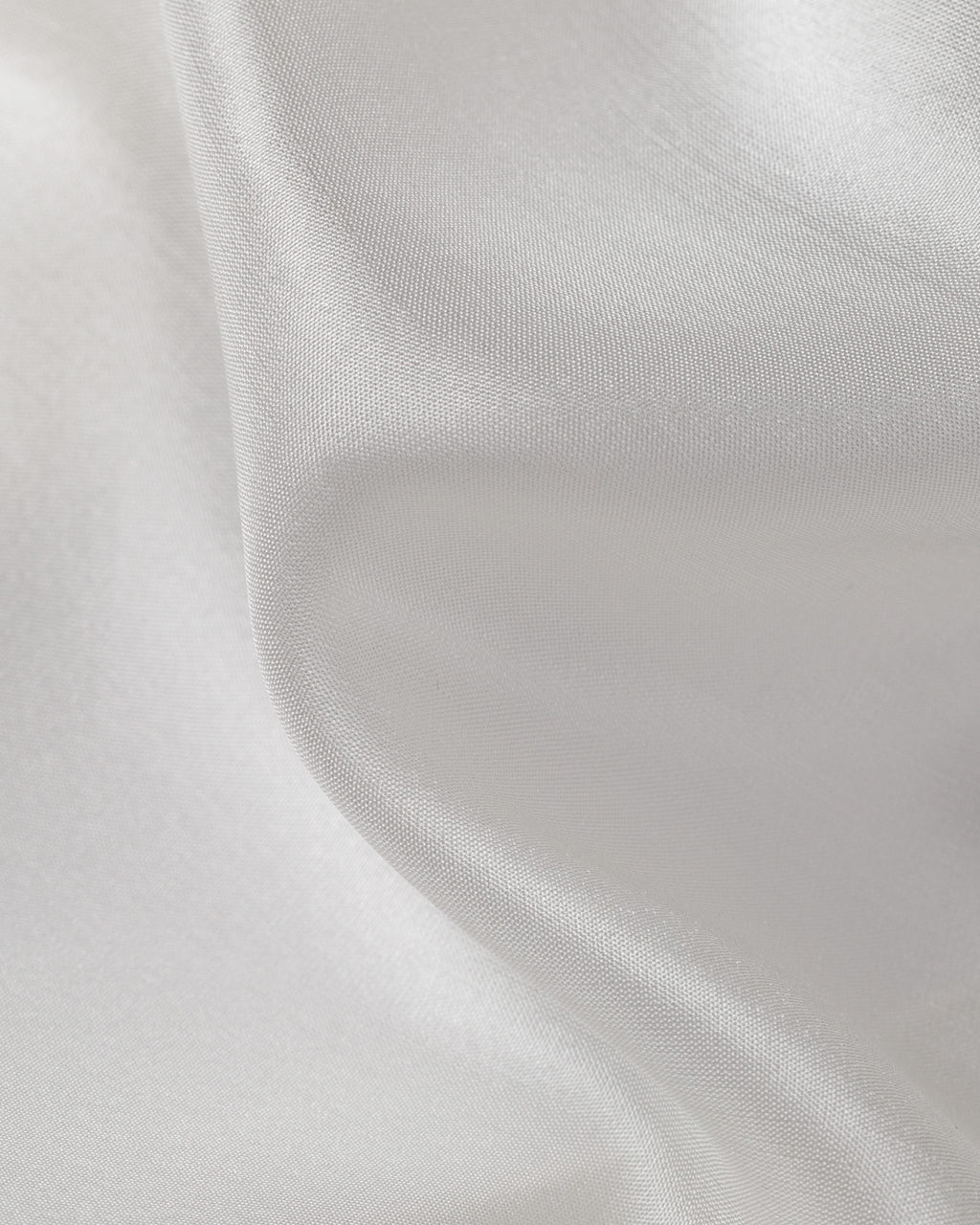 Close-up of undyed white silk Paj fabric with a subtle texture