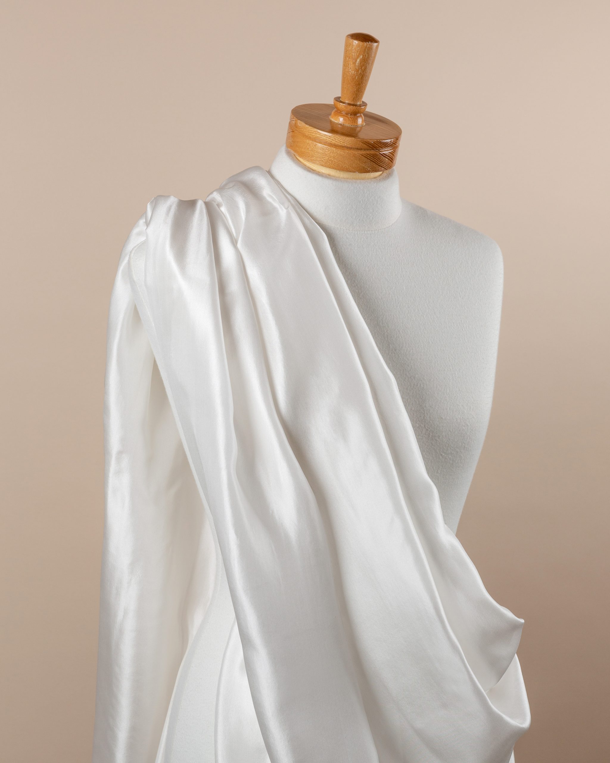 Undyed Paj Silk Fabric draped over a mannequin on a beige background