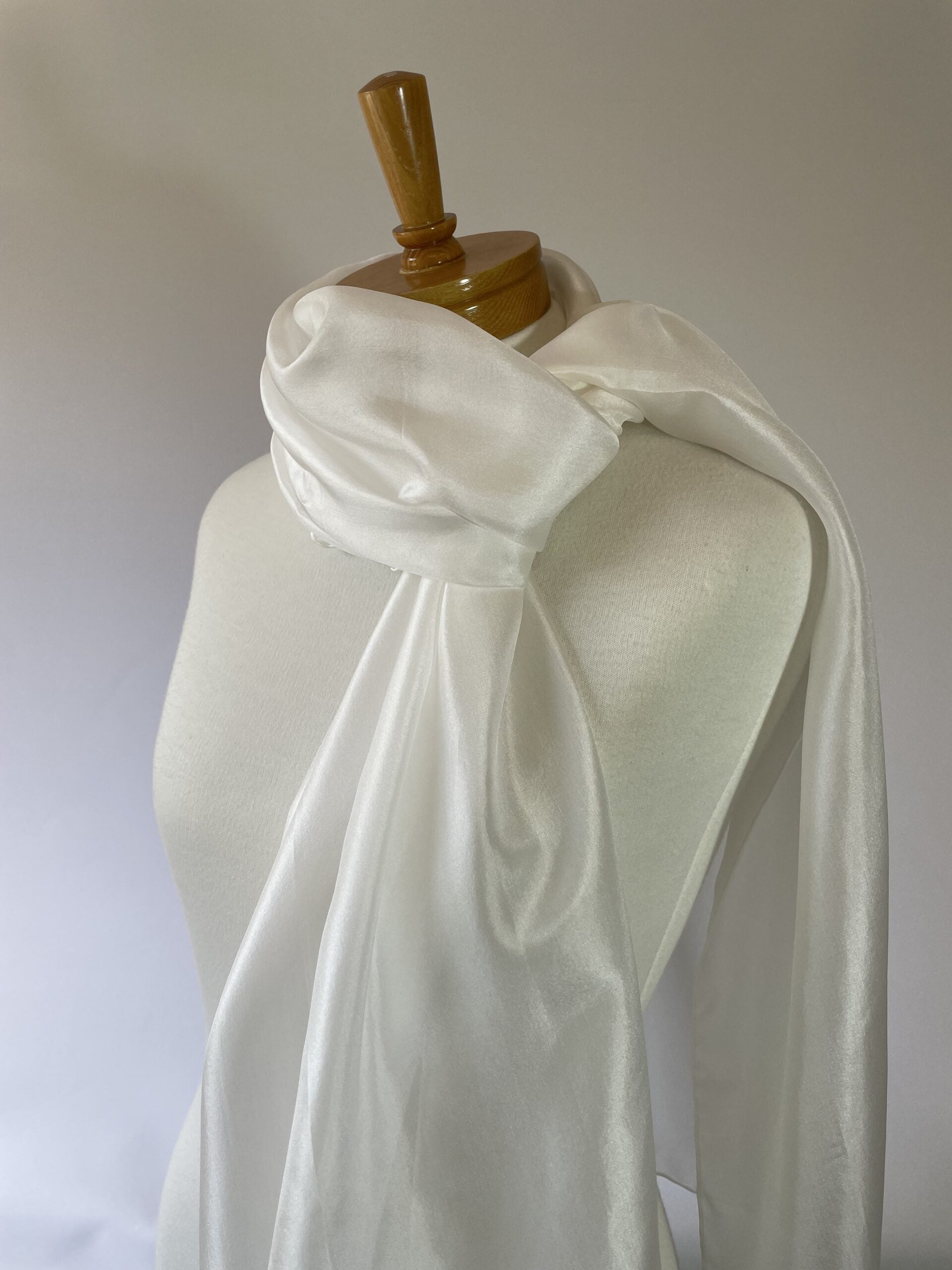 Undyed white Paj silk scarf draped over a mannequin against a plain background