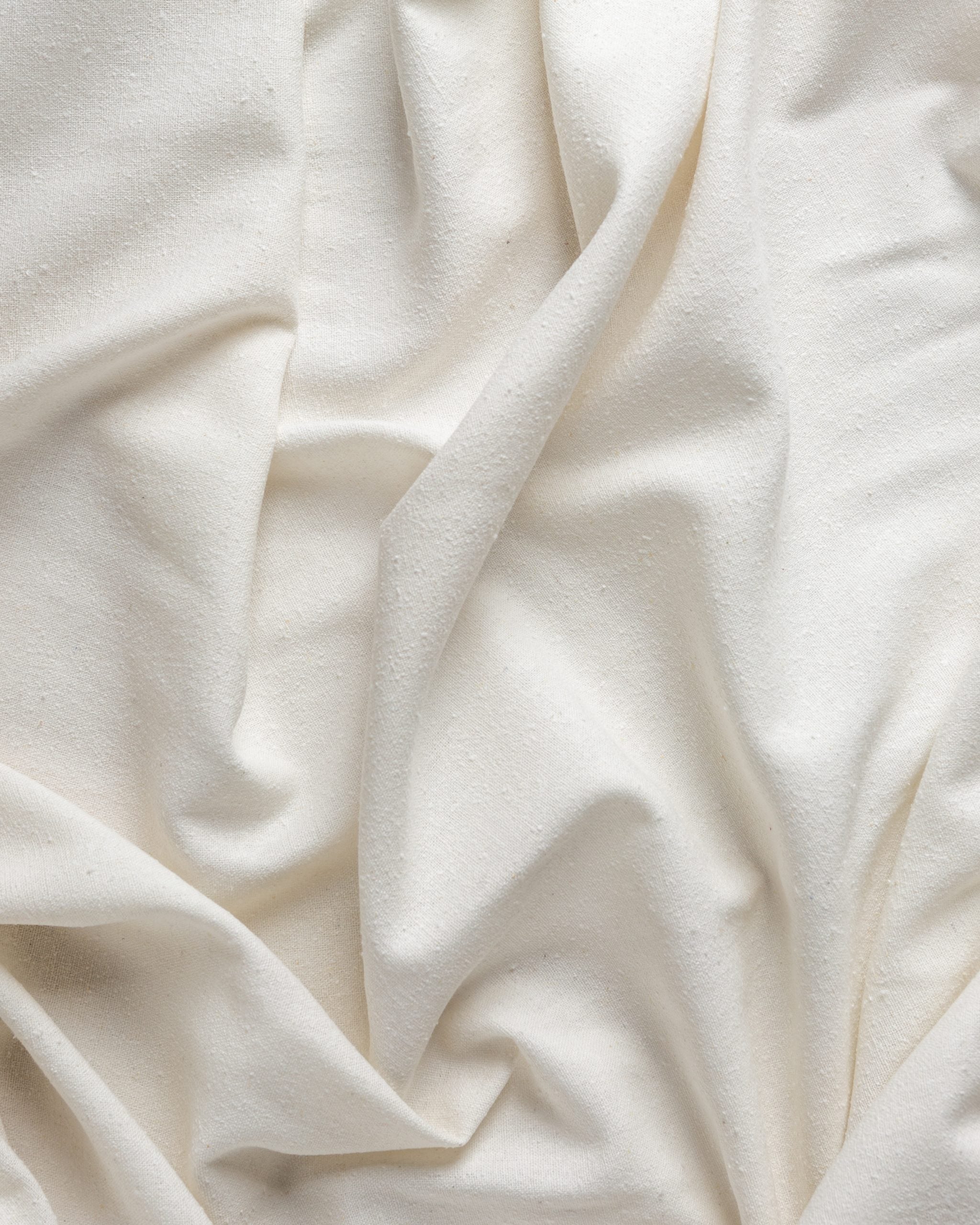 Close-up of undyed silk noil fabric with folds