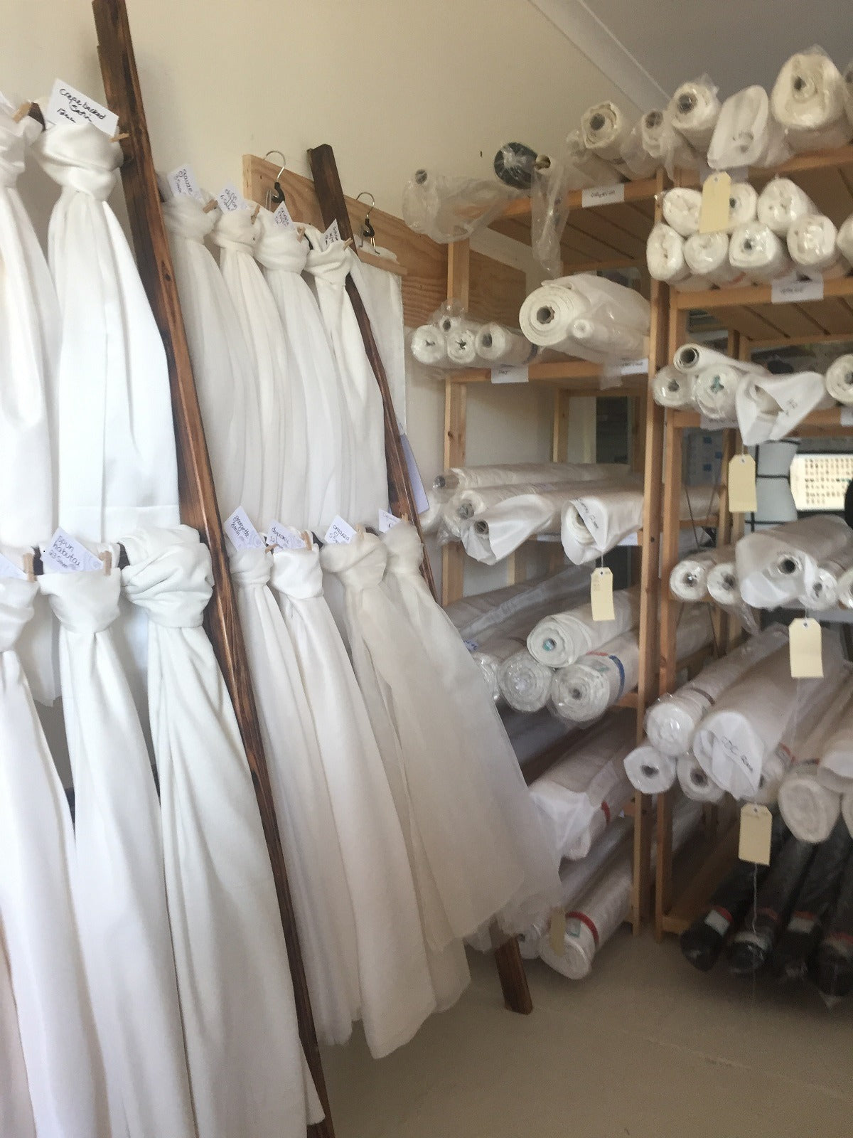 Fabric store with hanging and rolled-up fabric on shelves
