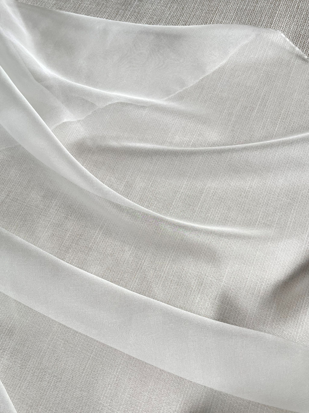 Close-up of Undyed Silk Chiffon fabric in transparent folds with a subtle texture