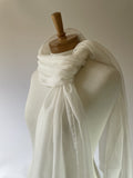 Undyed white silk chiffon scarf draped over a wooden mannequin on a plain background