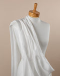 Undyed silk cotton voile fabric draped over a mannequin on a beige background