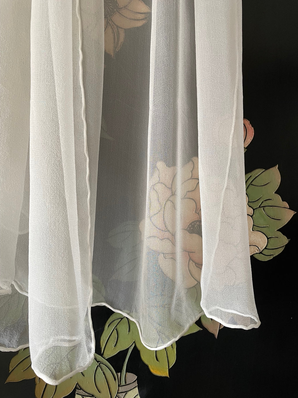 Sheer undyed white silk gauze scarf on a floral-patterned background