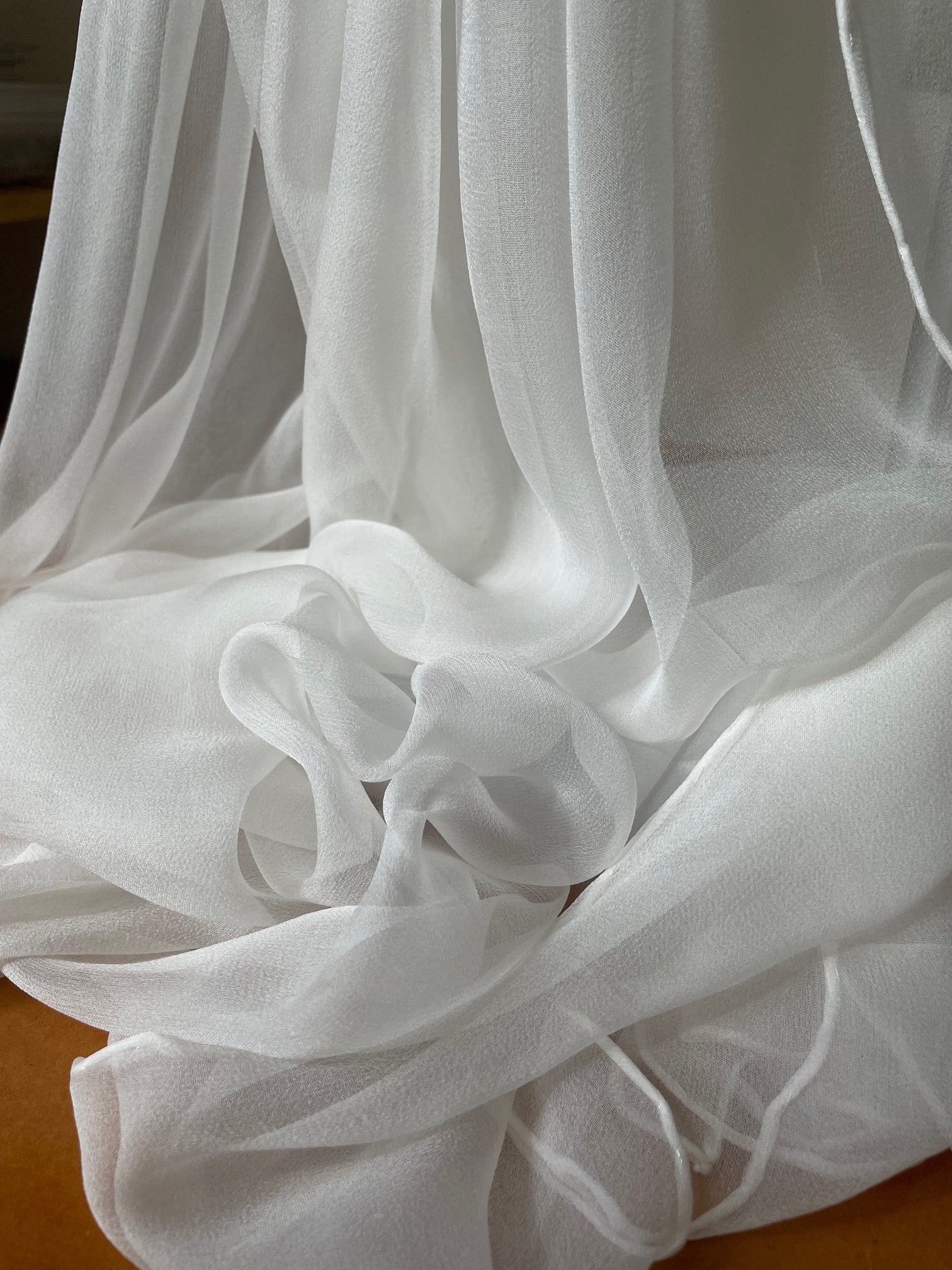 Undyed Silk Gauze Scarf sheer fabric with ruffled edges on a wooden surface