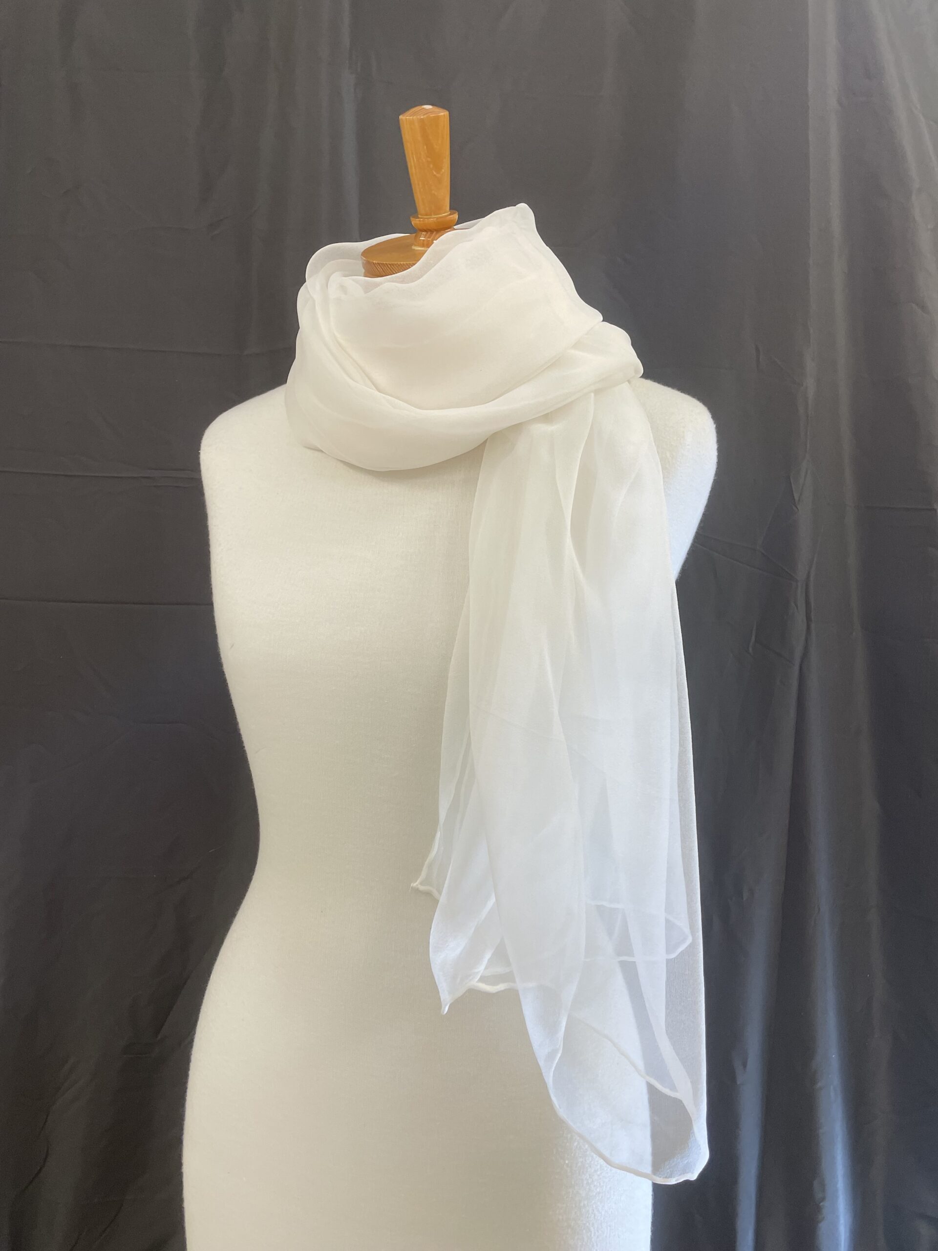 Undyed Silk Gauze scarf draped over a mannequin against a dark background