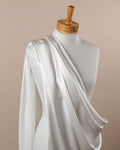 Undyed silk satin crepe fabric draped over a mannequin on a beige background