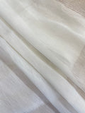 A close-up of folded undyed white sheer silk linen fabric with a subtle shimmer, showing its texture and semi-transparency.