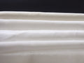 Close-up of undyed silk fabrics with a dark background