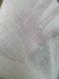 Close-up of a textured undyed finished wool gauze fabric showing its sheerness