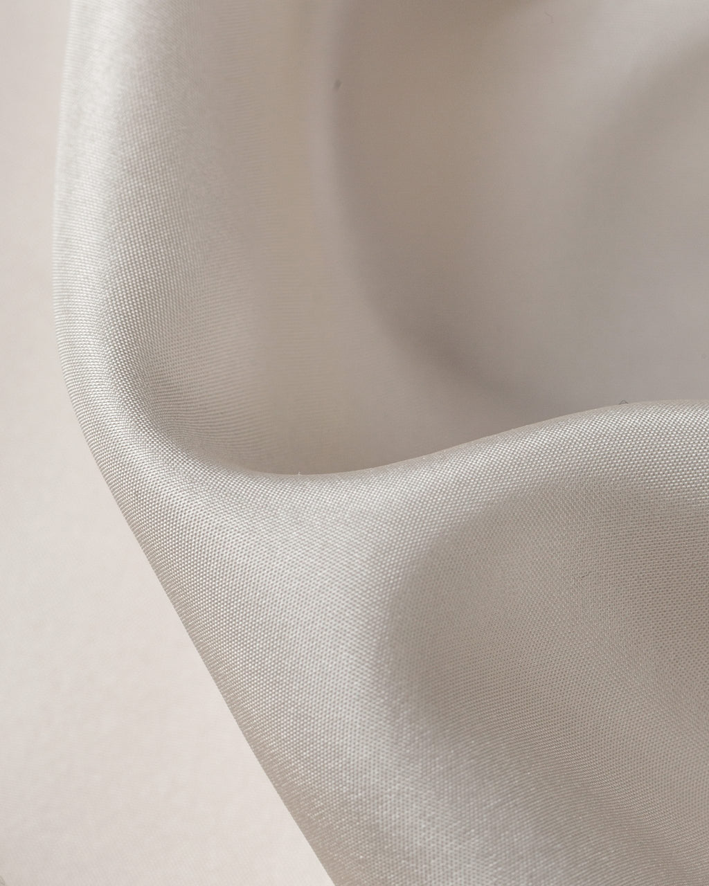 Close-up of habutai fabric texture on a light pink background